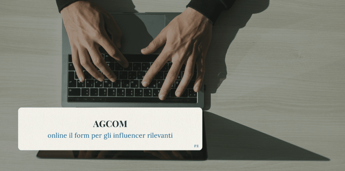 Mani su una tastiera di laptop, viste dall’alto, con un riquadro sovrapposto che riporta il titolo “AGCOM – online il form per gli influencer rilevanti”.
